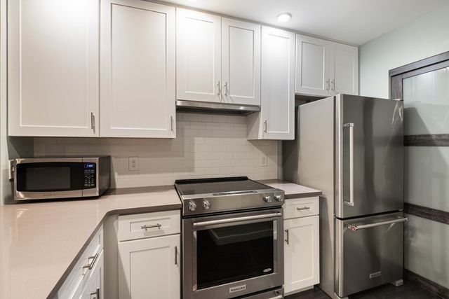a kitchen with refrigerator a stove a microwave and cabinets