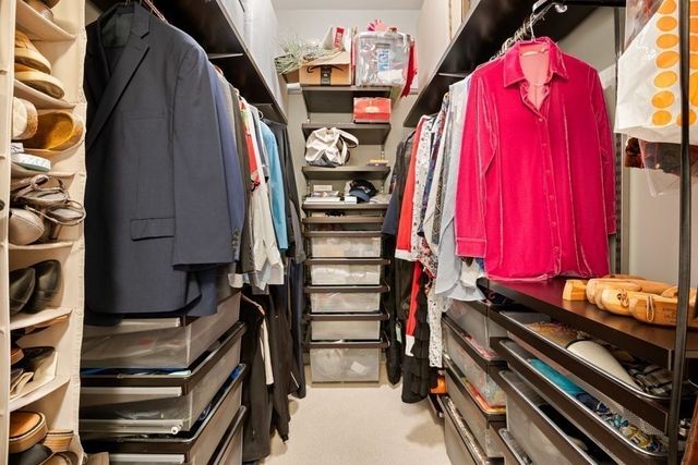 a view of walk in closet with clothes and shoes