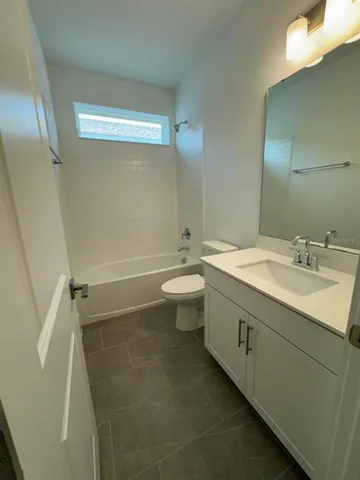 a bathroom with a granite countertop toilet and a sink
