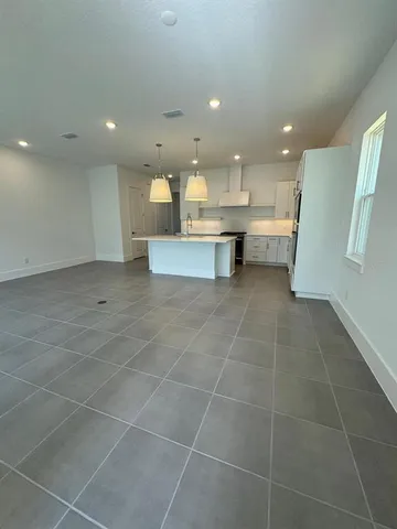 a view of kitchen with granite countertop window and white cabinets