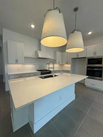 a kitchen with a sink cabinets and a wooden floor