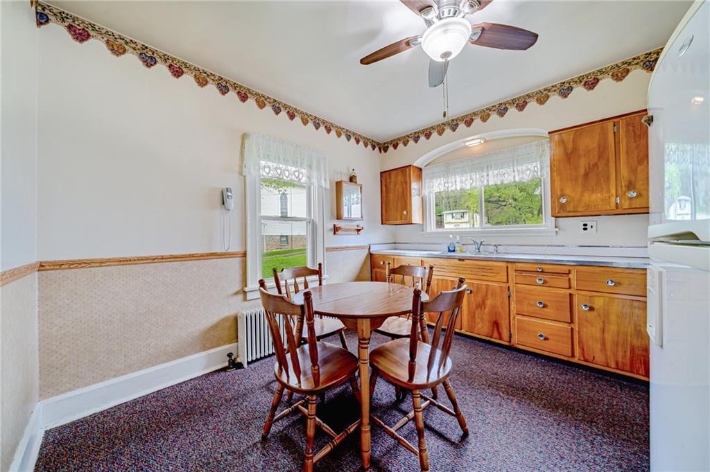 2375 Mt Pleasant Road Ruffs Dale, PA 15679 - Photo 7 of 31 a dining room with wooden floor a chandelier fan a wooden table and chairs