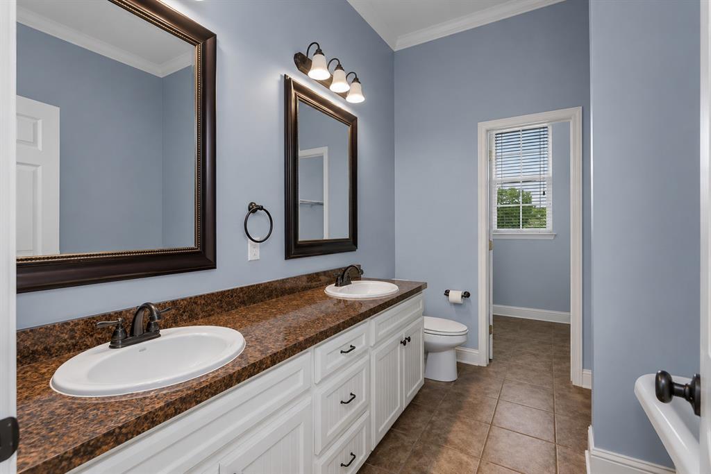 179 Ranchtown Road Elm Grove, LA 71051 - Photo 13 of 26 Bathroom vanity featuring dual under-mount sinks, a brown speckled countertop, and white base cabinetry with black hardware