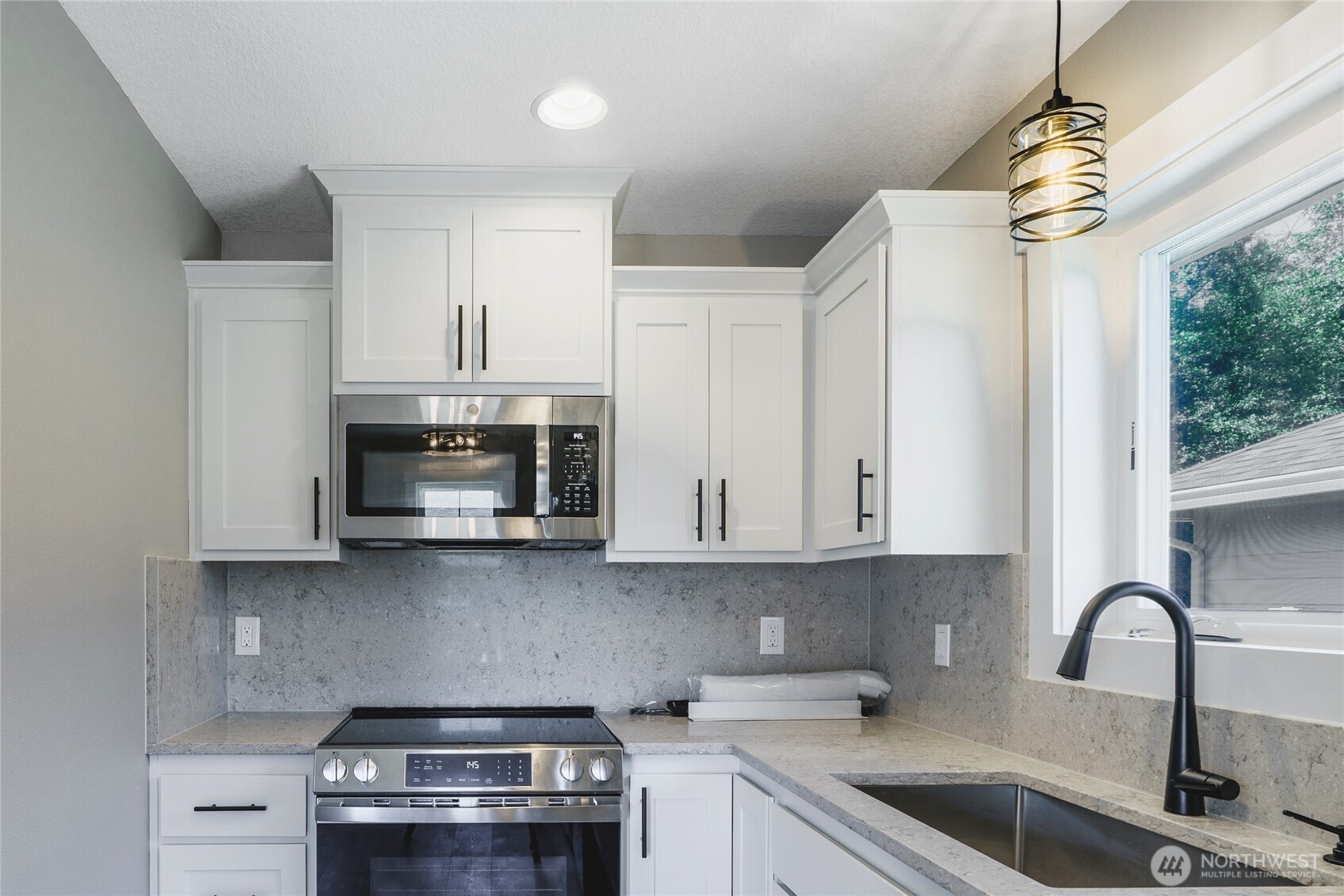 117 7th Street Southwest Long Beach, WA 98631 - Photo 7 of 25 a kitchen with stainless steel appliances granite countertop a sink a stove and a microwave