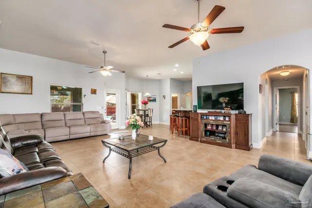 a living room with furniture kitchen view and a flat screen tv