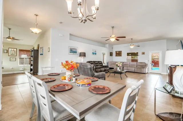 a living room with furniture kitchen view and a chandelier