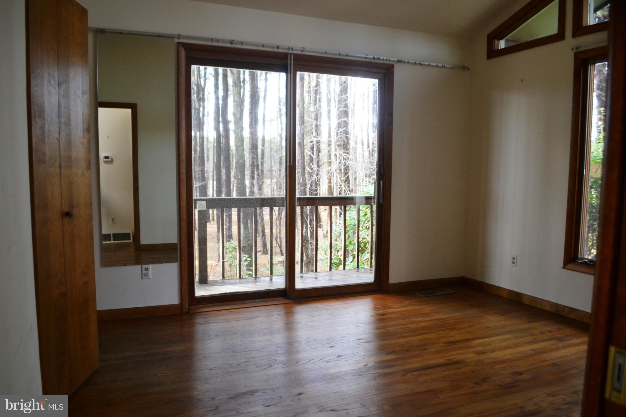7223 Drum Point Road St. Michaels, MD 21663 - Photo 18 of 38 a view of an empty room with wooden floor and a window