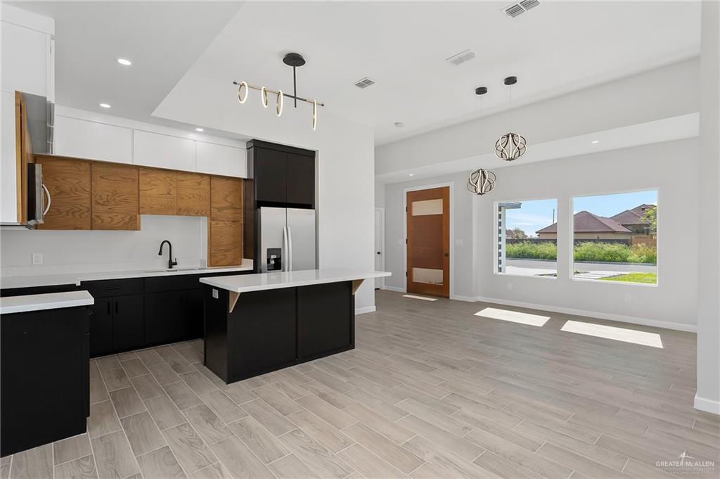 2302 San Pascual Street San Juan, TX 78589 - Photo 5 of 13 a large kitchen with stainless steel appliances a large counter top a stove and a refrigerator