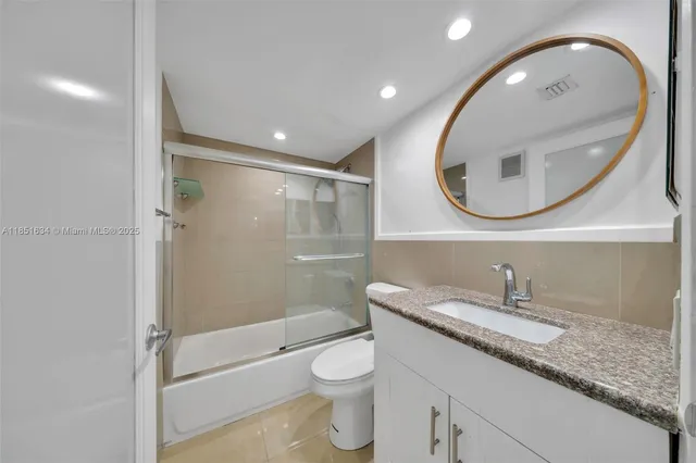 an empty room with windows and chandelier fan