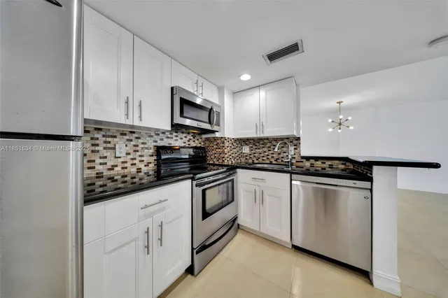 a kitchen with granite countertop cabinets stainless steel appliances and sink