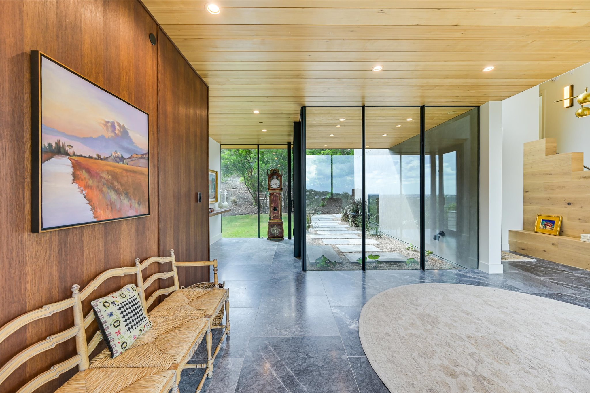 2405 Deer Pass Austin, TX 78746 - Photo 3 of 28 Entryway featuring a wall of windows, wooden walls, wood ceiling, and stairs