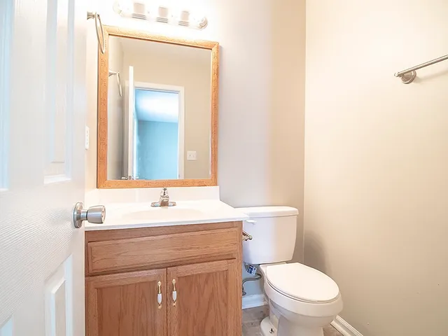 a bathroom with a sink vanity mirror and toilet