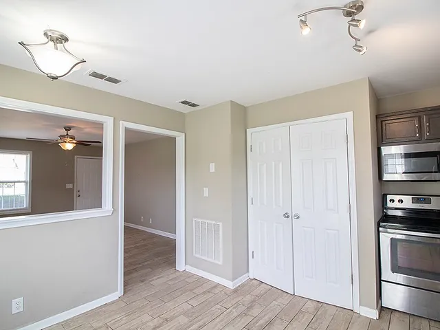 a view of a kitchen with refrigerator and wooden floor