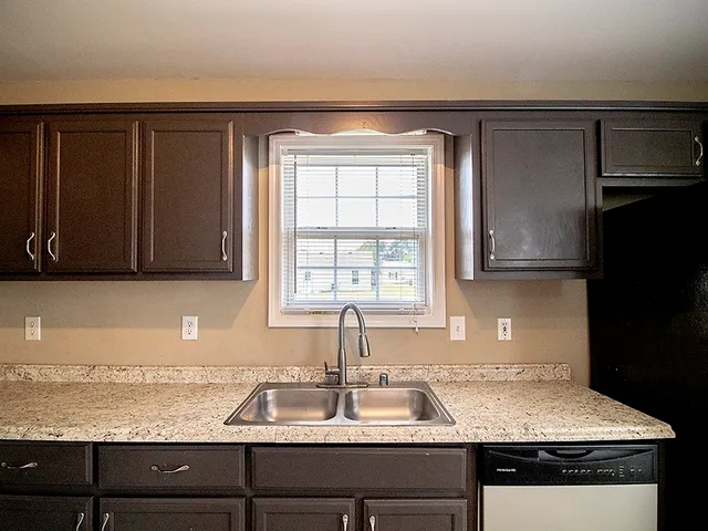 a kitchen with granite countertop a sink stainless steel appliances and cabinets