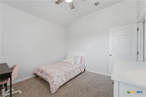 a bedroom with a bed and a chandelier fan