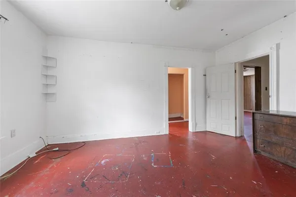an empty room with wooden floor and a window