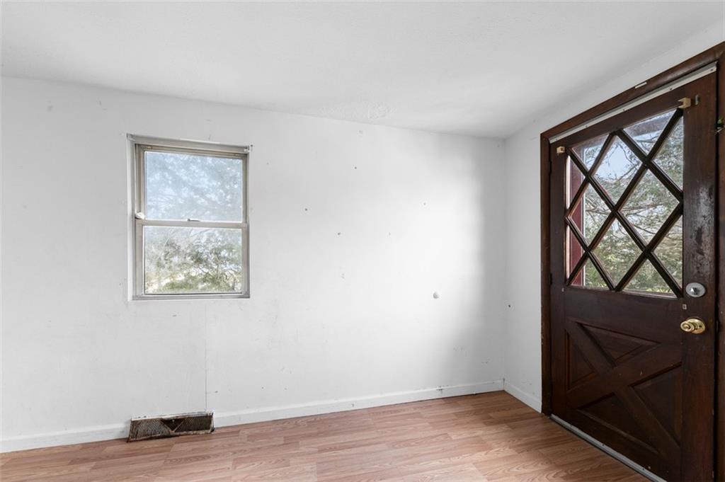 303 Agnew Road Jeannette, PA 15644 - Photo 21 of 28 an empty room with wooden floor and a window