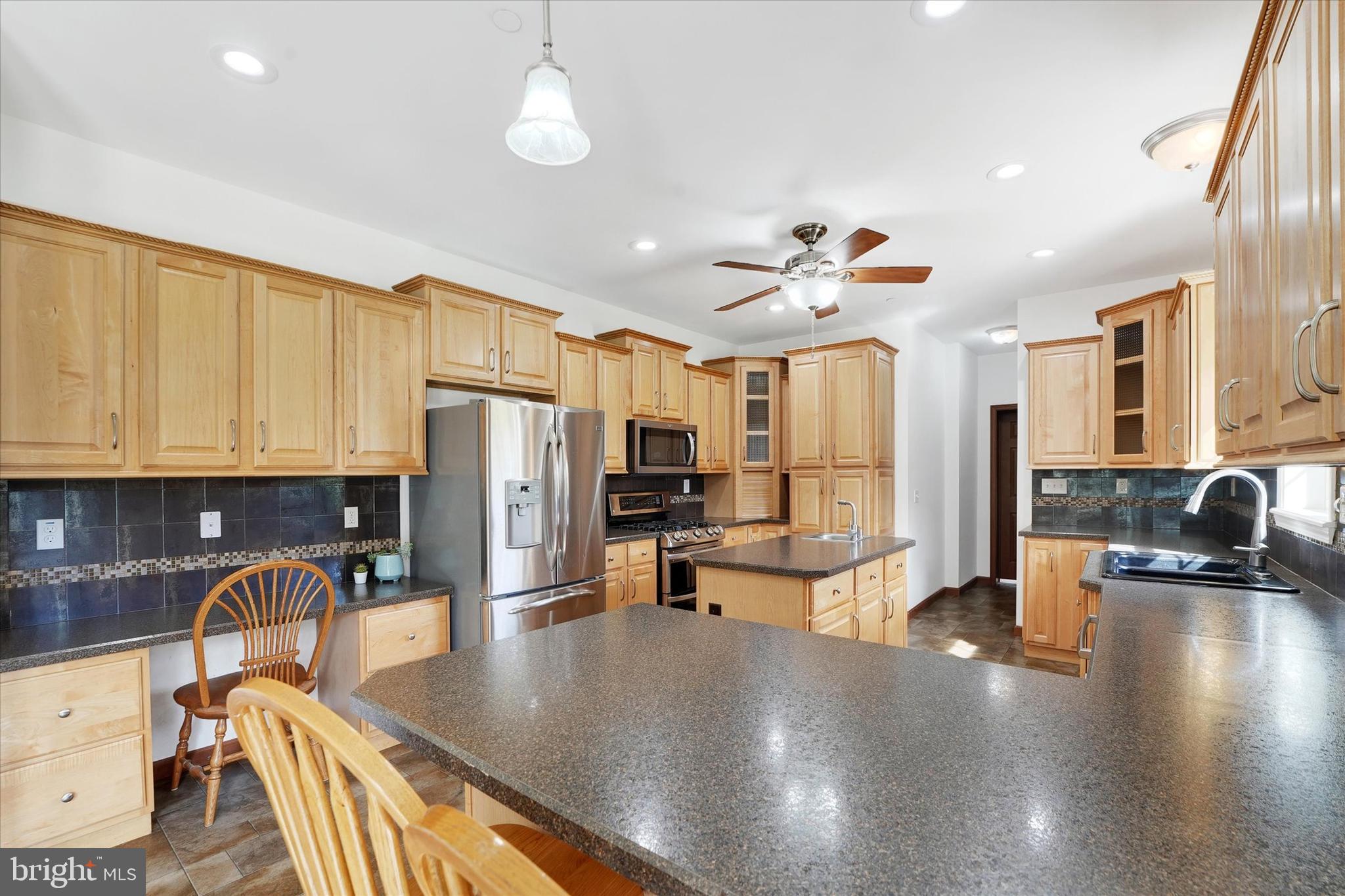 249 Floral Way Rising Sun, MD 21911 - Photo 30 of 65 a kitchen with stainless steel appliances granite countertop a refrigerator a sink dishwasher a stove and white countertops with wooden floor