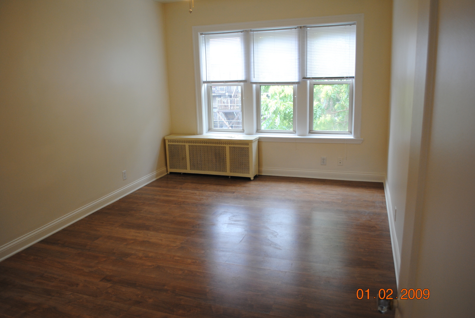 7635 South Yates Boulevard Chicago, IL 60649 - Photo 11 of 17 an empty room with wooden floor and windows