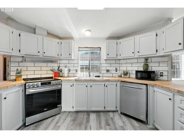 a kitchen with granite countertop white cabinets and white appliances