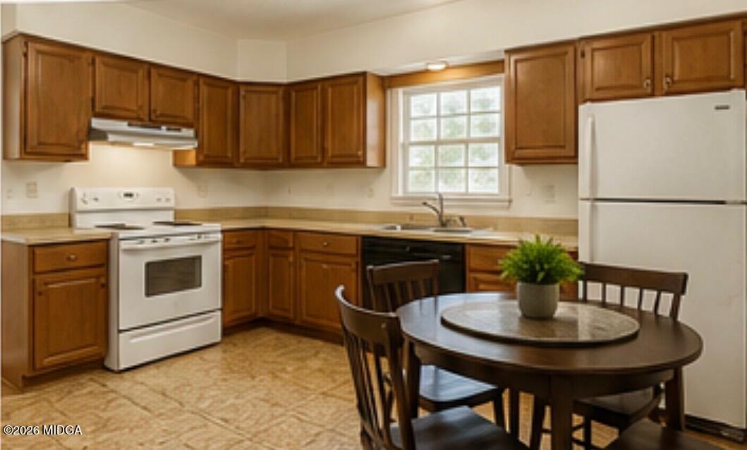 1624 Randall Road Macon, GA 31206 - Photo 3 of 5 a kitchen with stainless steel appliances a white table and chairs in it