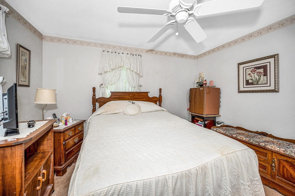 19 Reo Road Maynard, MA 01754 - Photo 12 of 41 a bedroom with a bed and a chandelier