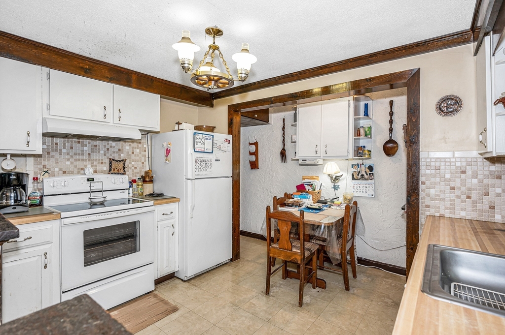 19 Reo Road Maynard, MA 01754 - Photo 22 of 41 a kitchen with stainless steel appliances kitchen island a table and chairs in it