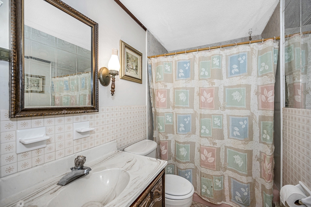 19 Reo Road Maynard, MA 01754 - Photo 10 of 41 a bathroom with a sink a toilet a mirror and shower