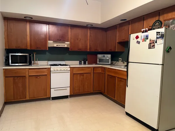 a utility room with refrigerator a stove a sink and cabinets