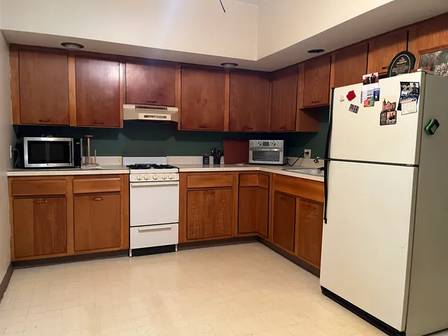 a utility room with refrigerator a stove a sink and cabinets