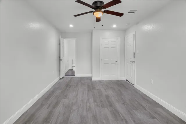 an empty room with wooden floor a ceiling fan and closet