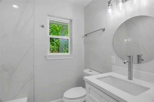 a white toilet sitting next to a bathroom sink