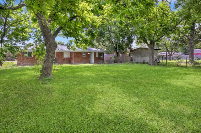 a house is sitting in middle od the grass