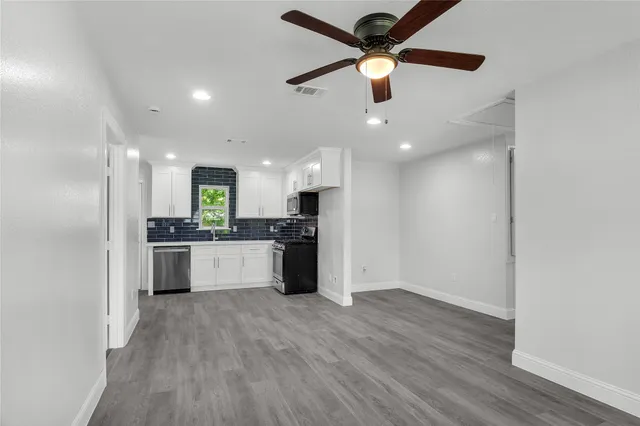 a large kitchen with stainless steel appliances kitchen island a sink and a refrigerator
