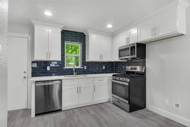 a kitchen with a sink stove and microwave
