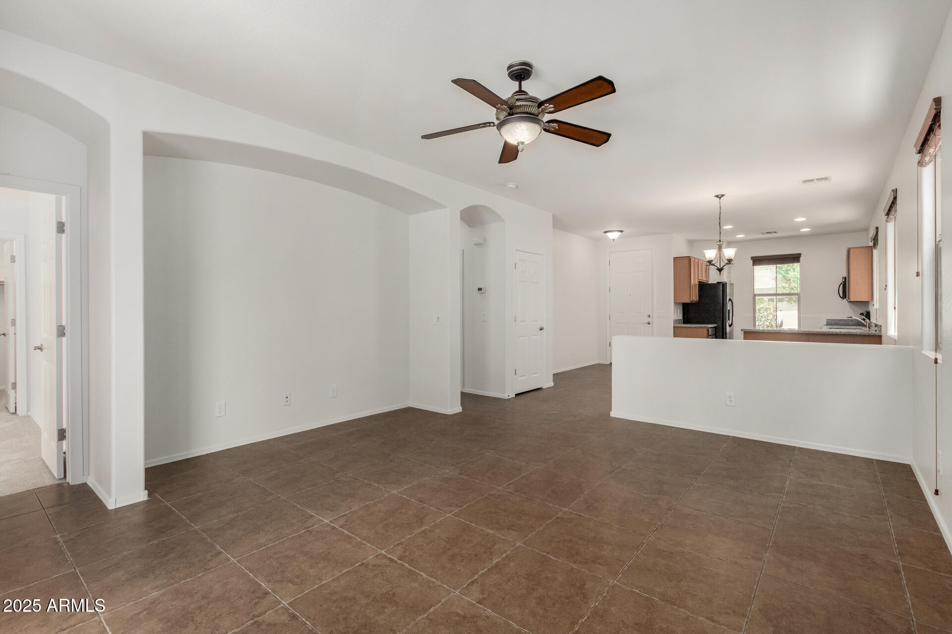 3313 West Gran Paradiso Drive Phoenix, AZ 85086 - Photo 10 of 31 an empty room with a kitchen and a ceiling fan