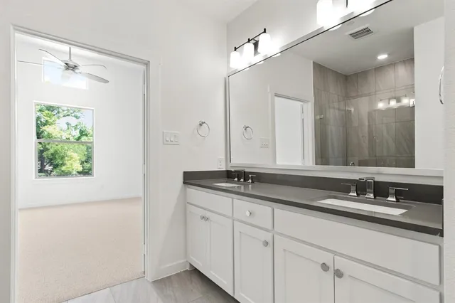 a bathroom with a granite countertop sink a mirror and a shower