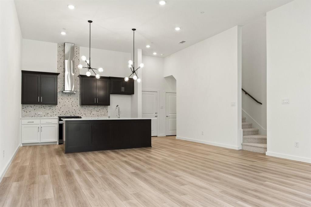 8513 Del Rio Trail Wylie, TX 75098 - Photo 9 of 33 a large kitchen with stainless steel appliances kitchen island a refrigerator and a flat screen tv