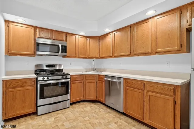 a kitchen with granite countertop cabinets stainless steel appliances and a sink