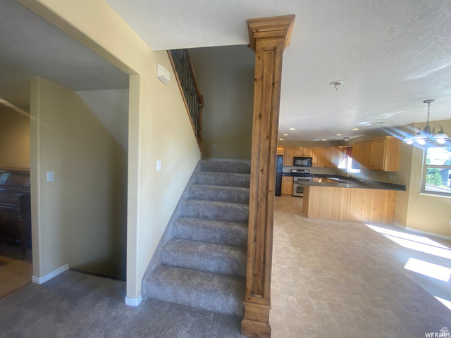83 Canterbury Circle Logan, UT 84321 - Photo 2 of 23 Stairway with hanging lights and tile patterned floors