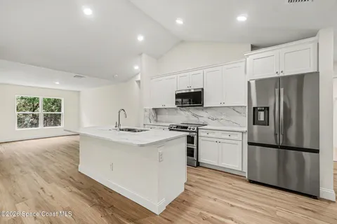 a kitchen with stainless steel appliances granite countertop a refrigerator stove a sink and a microwave