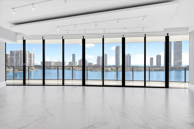 a view of an empty room with wooden floor and furniture