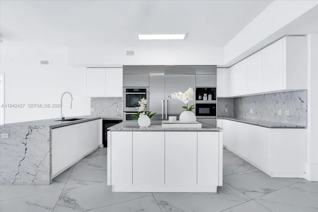 a kitchen with white cabinets and sink