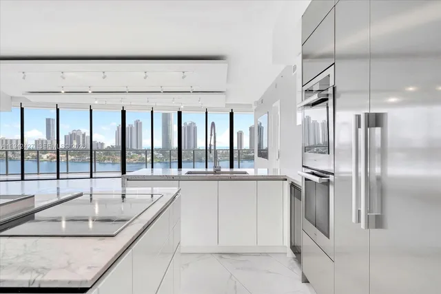 a kitchen with stainless steel appliances granite countertop a sink and a refrigerator