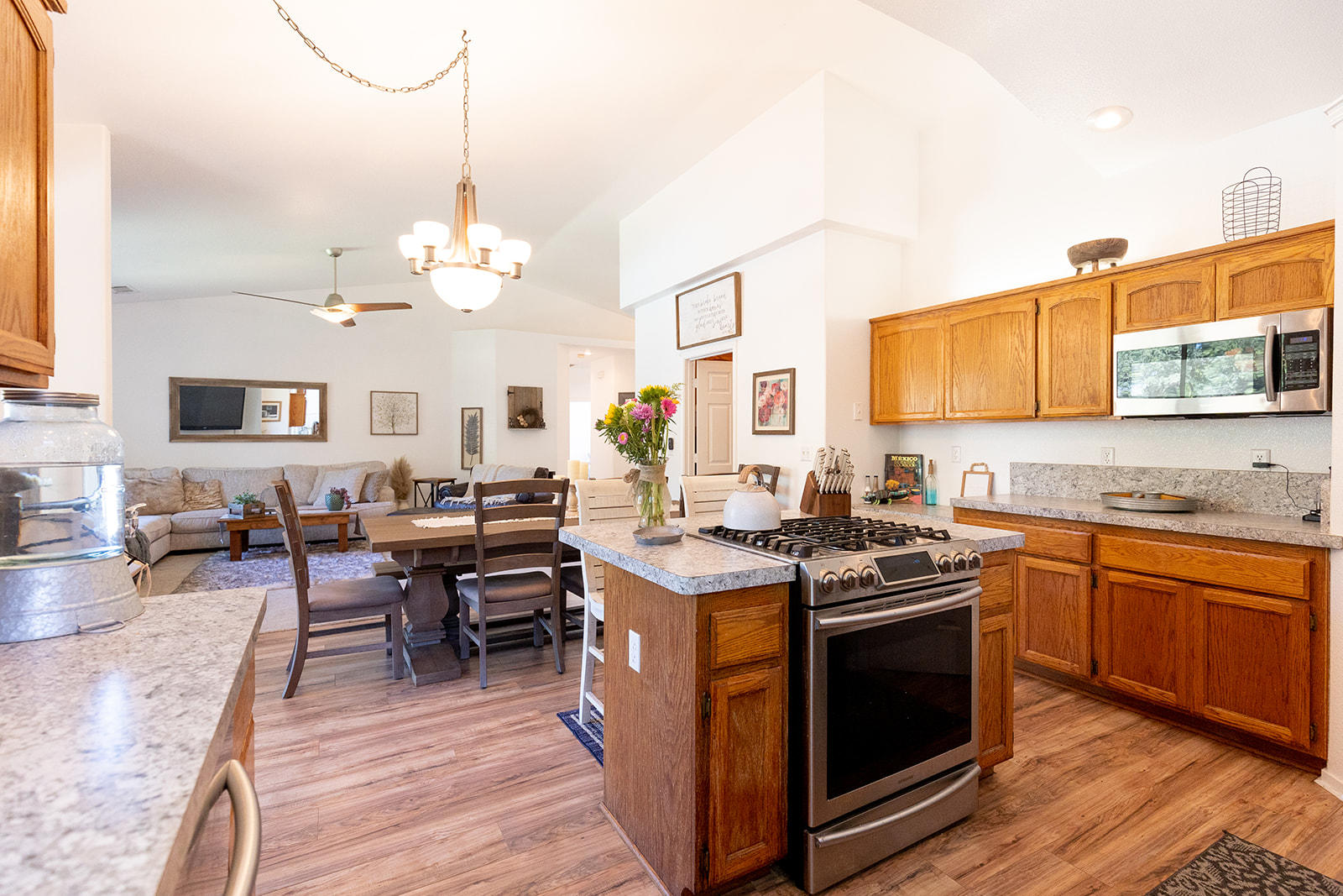 3363 Lawrence Road Redding, CA 96002 - Photo 11 of 33 a open kitchen with stainless steel appliances granite countertop a stove top oven a sink dishwasher and white cabinets with wooden floor