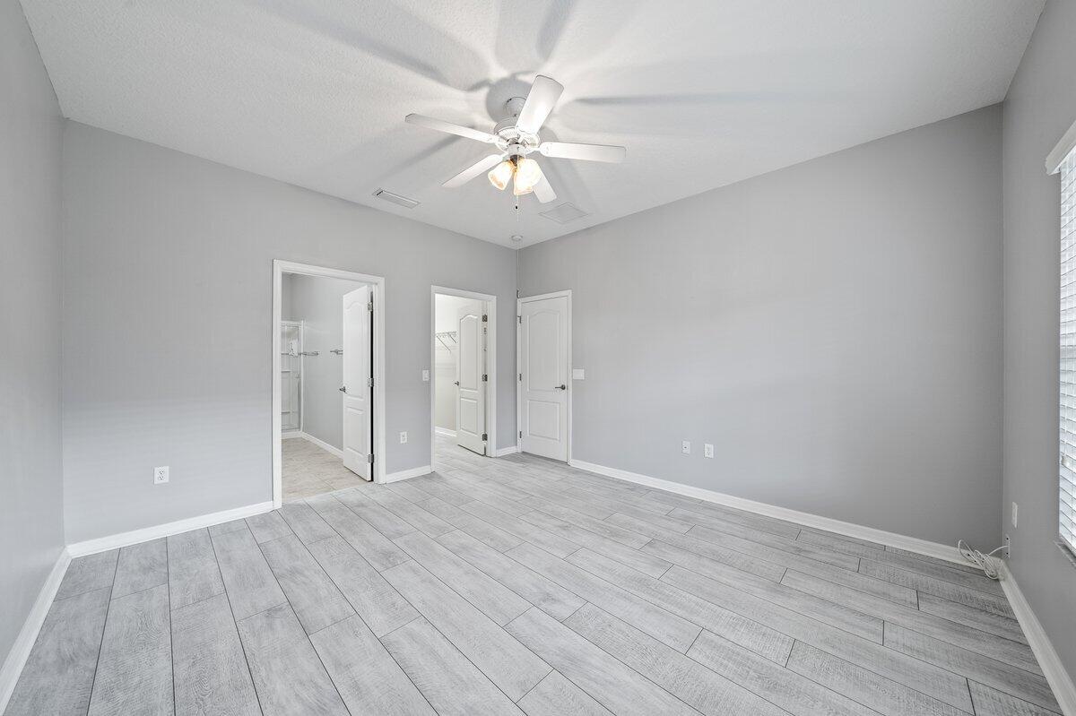 2980 Le Conte Street Melbourne, FL 32940 - Photo 18 of 25 an empty room with wooden floor fan and windows