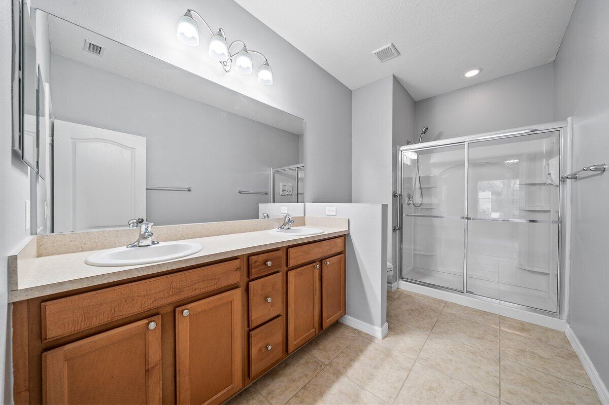 2980 Le Conte Street Melbourne, FL 32940 - Photo 20 of 25 a bathroom with a double vanity sink mirror and shower