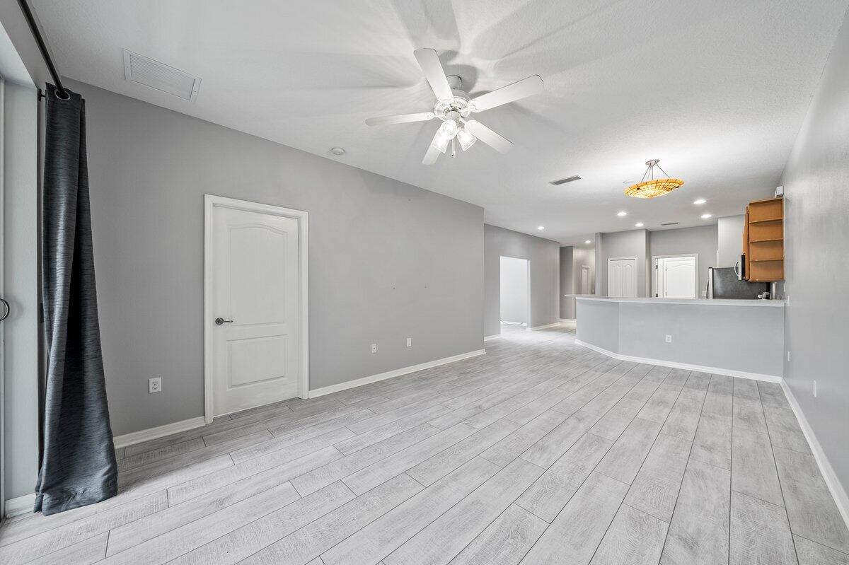 2980 Le Conte Street Melbourne, FL 32940 - Photo 7 of 25 a view of a kitchen with wooden floor and a ceiling fan