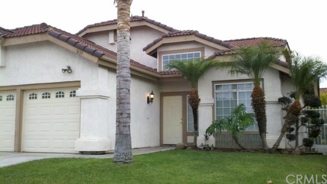 a view of a house with brick walls and a yard with plants