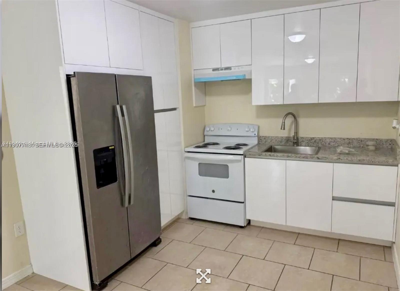 22210 Southwest 116th Avenue, Unit D Miami, FL 33170 - Photo 3 of 4 a kitchen with white cabinets and refrigerator